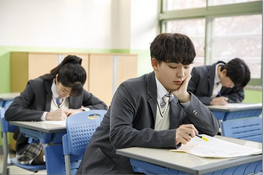 교실에서 교재를 읽는 학생