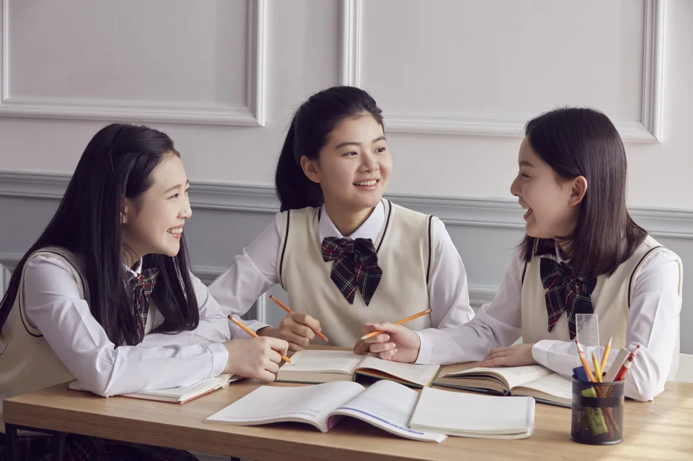 교재를 펼쳐 대화하는 학생들