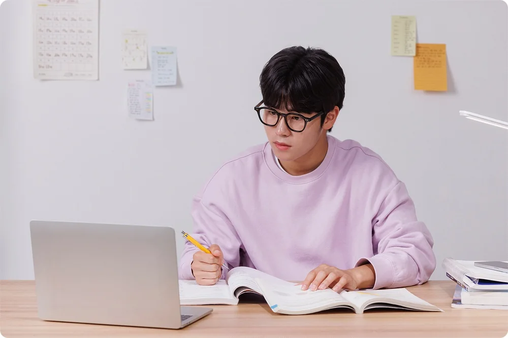 책과 노트북을 펼친 학생