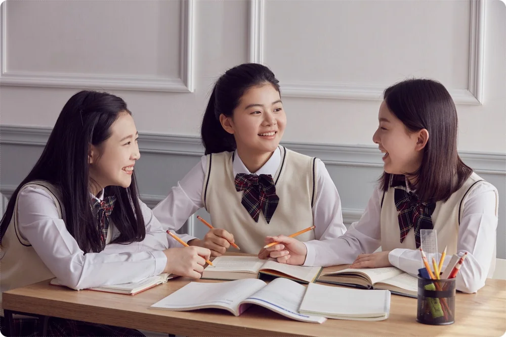 교재를 펼쳐 대화하는 학생들