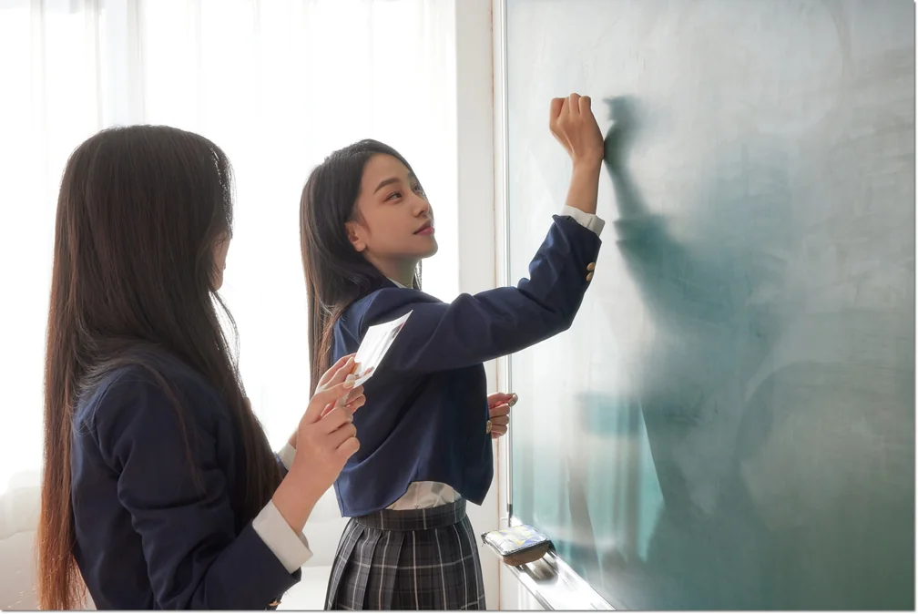 칠판 앞에서 함께 설명을 살펴보는 학생들