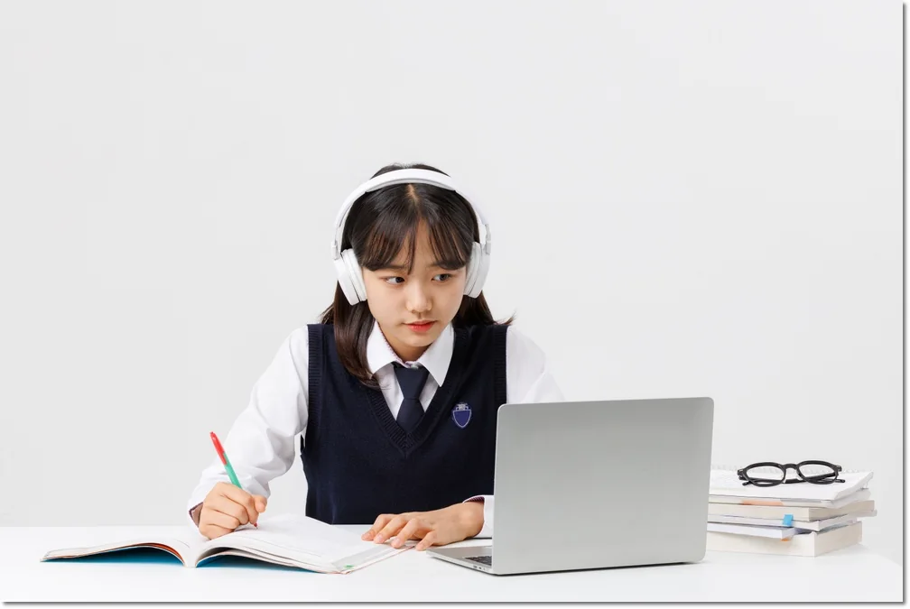 이어폰을 쓰고 교재를 보는 학생
