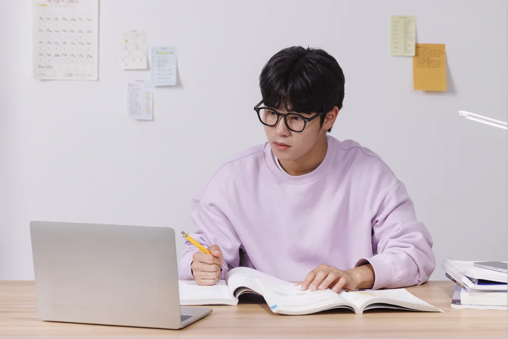 책과 노트북을 펼친 학생
