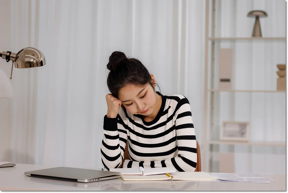 노트에 필기하며 교재를 보는 학생