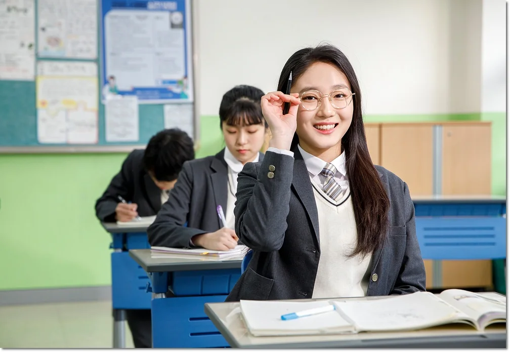 교실 책상에서 책을 펼치고 앉은 학생