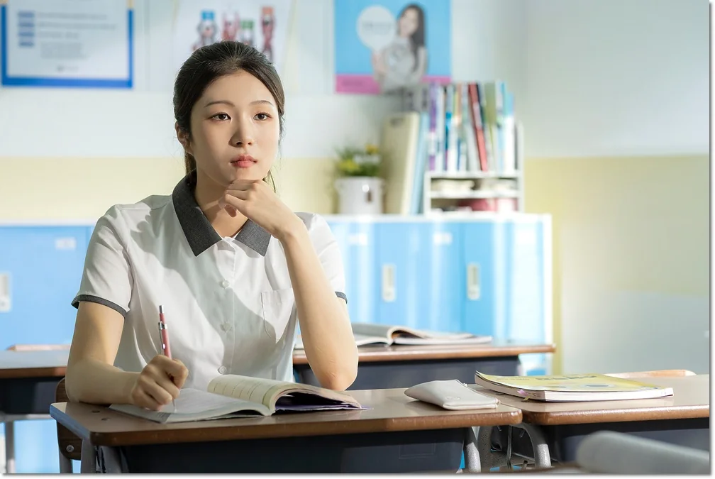 교실 책상에서 펼친 책을 보는 학생