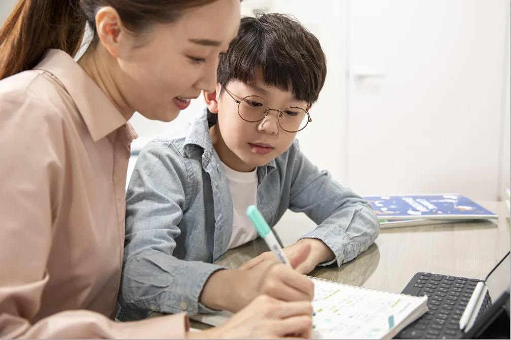 어른과 아이가 함께 교재를 살펴보는 모습